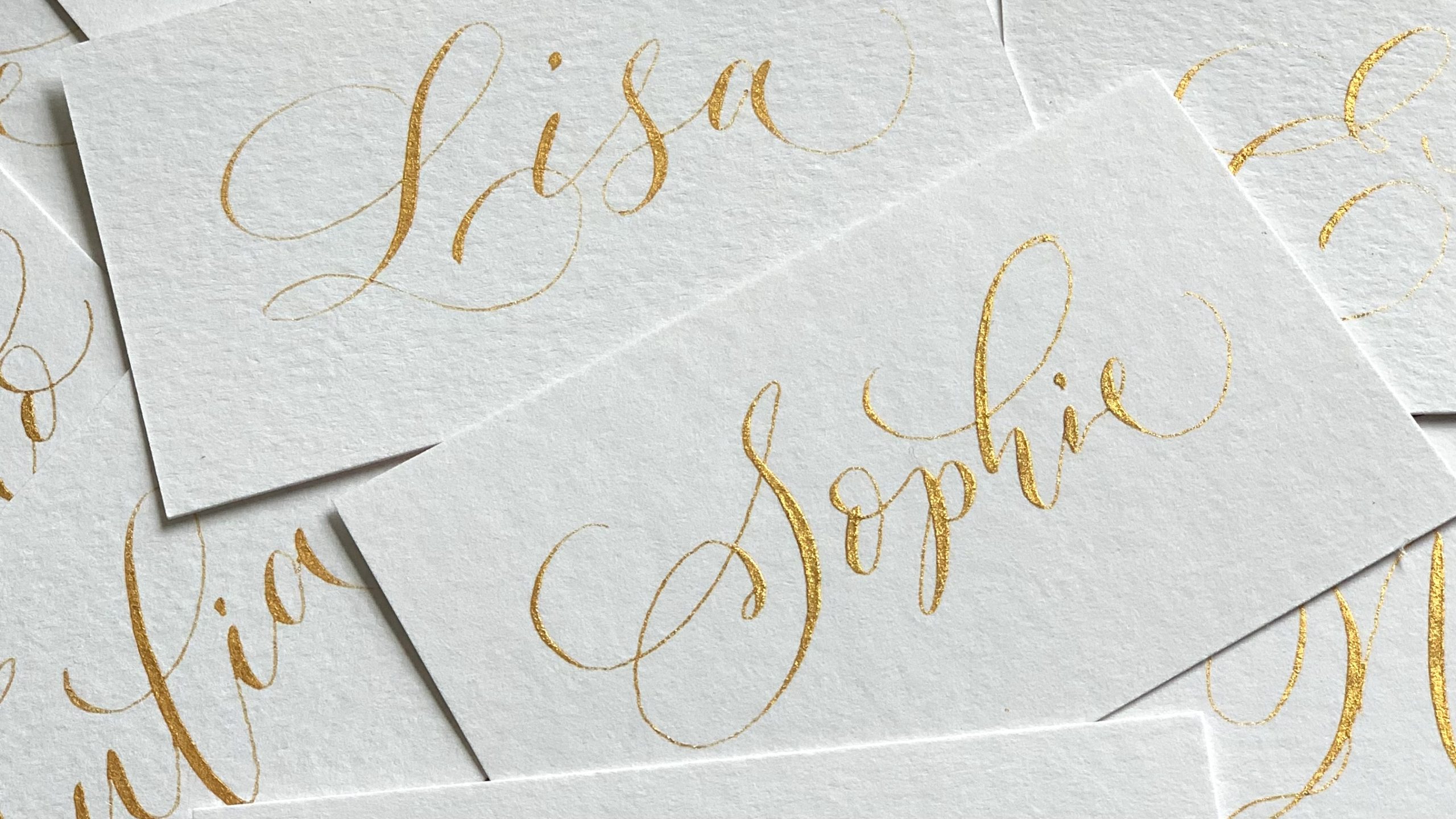 Calligraphed place cards with gold ink