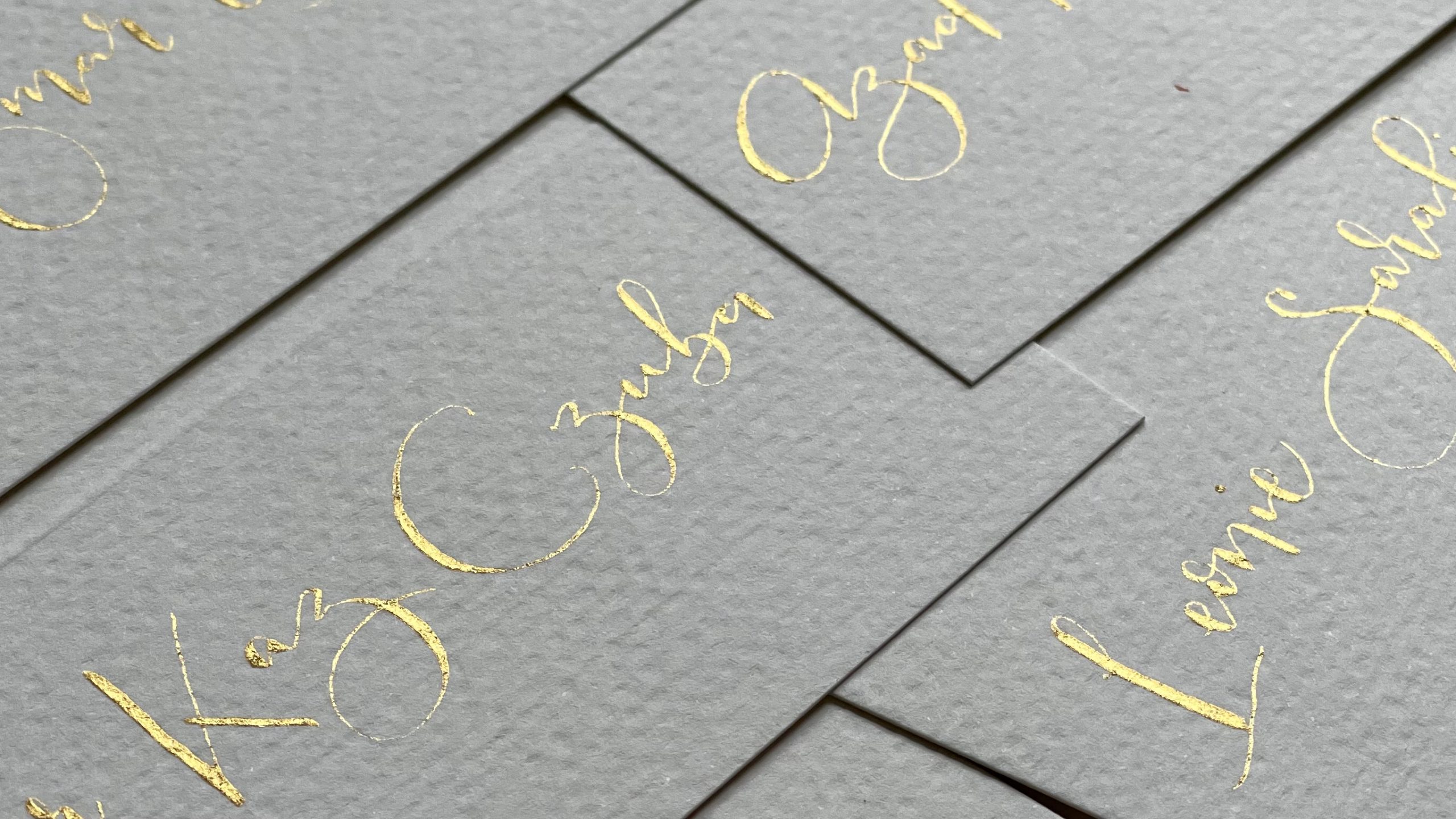Calligraphed place cards with gold ink